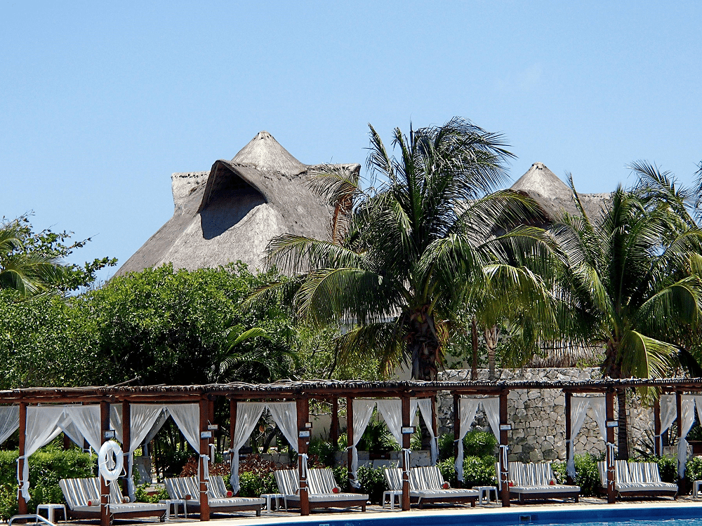 Tropical resort with palm trees and cabanas.