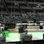 Stage setup with lighting and equipment in an arena.
