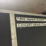 A sign with explicit language about a concert grand piano.