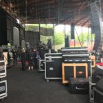 Stage crew setting up equipment for a live performance inside a large venue.