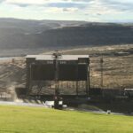 A large outdoor screen setup on a hill overlooking a vast landscape.
