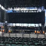Empty stage setup with chairs and crew preparing for an event.