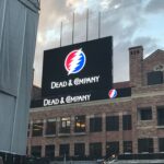 Digital billboard displaying the Grateful Dead logo and text "DEAD & COMPANY" on a building.