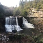 A serene waterfall cascading over rocky cliffs surrounded by trees.