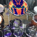 Colorful drum set with vibrant bass drum art and multiple percussion instruments.