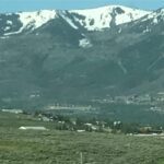 Snow-capped mountains overlook a valley with a small town.