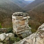 A unique rock formation resembling a face on a mountain ridge.