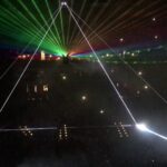 Laser light show with colorful beams in a dark venue.